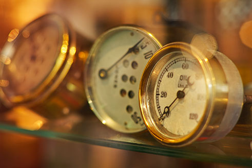 A still-life image of brass speedometers in a cultural heritage museum.